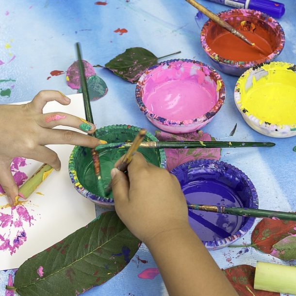 Young people painting with leaves in Art