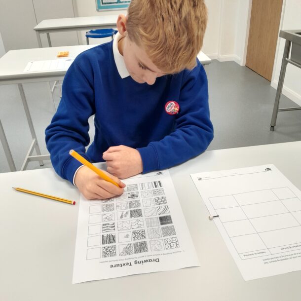 a picture of a child sat at their desk wearing school uniform