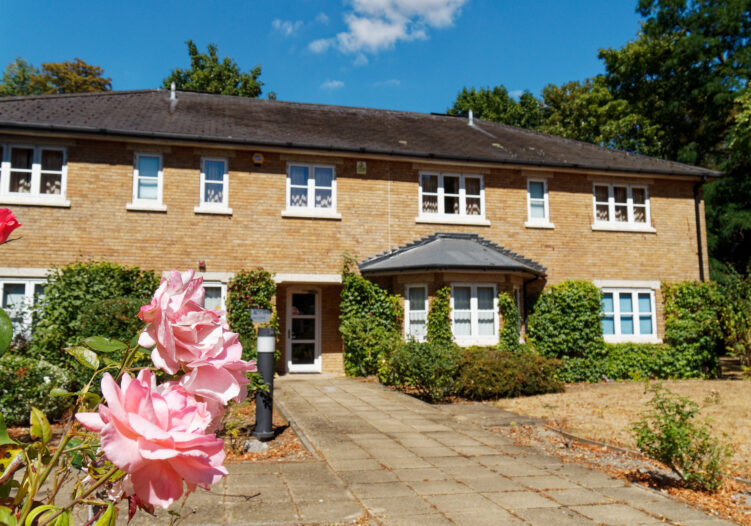 Photo of exterior of Selwyn Hall School with pink flowers in front of the building
